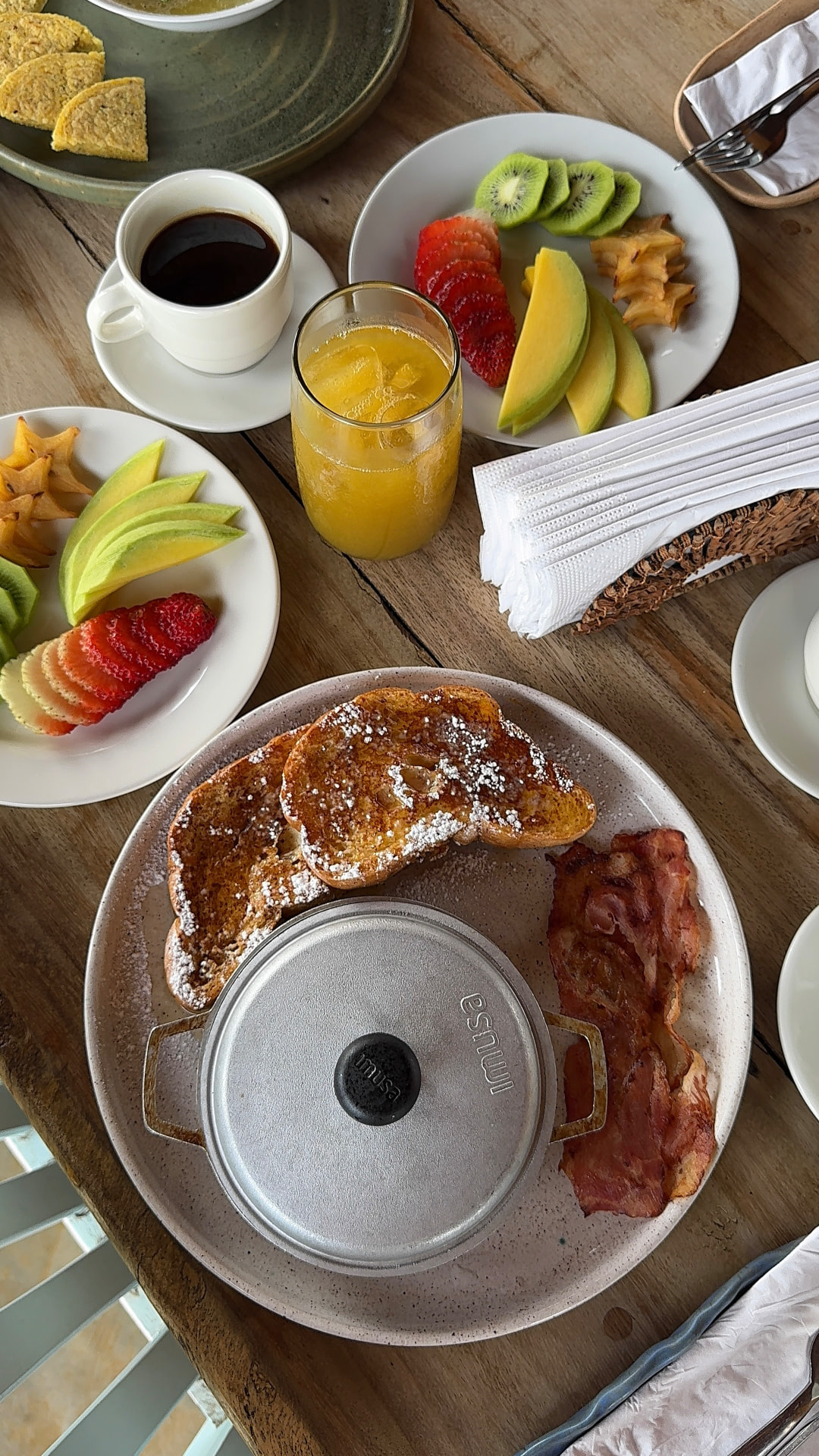 Desayuno con tostadas, tocineta, frutas y jugo