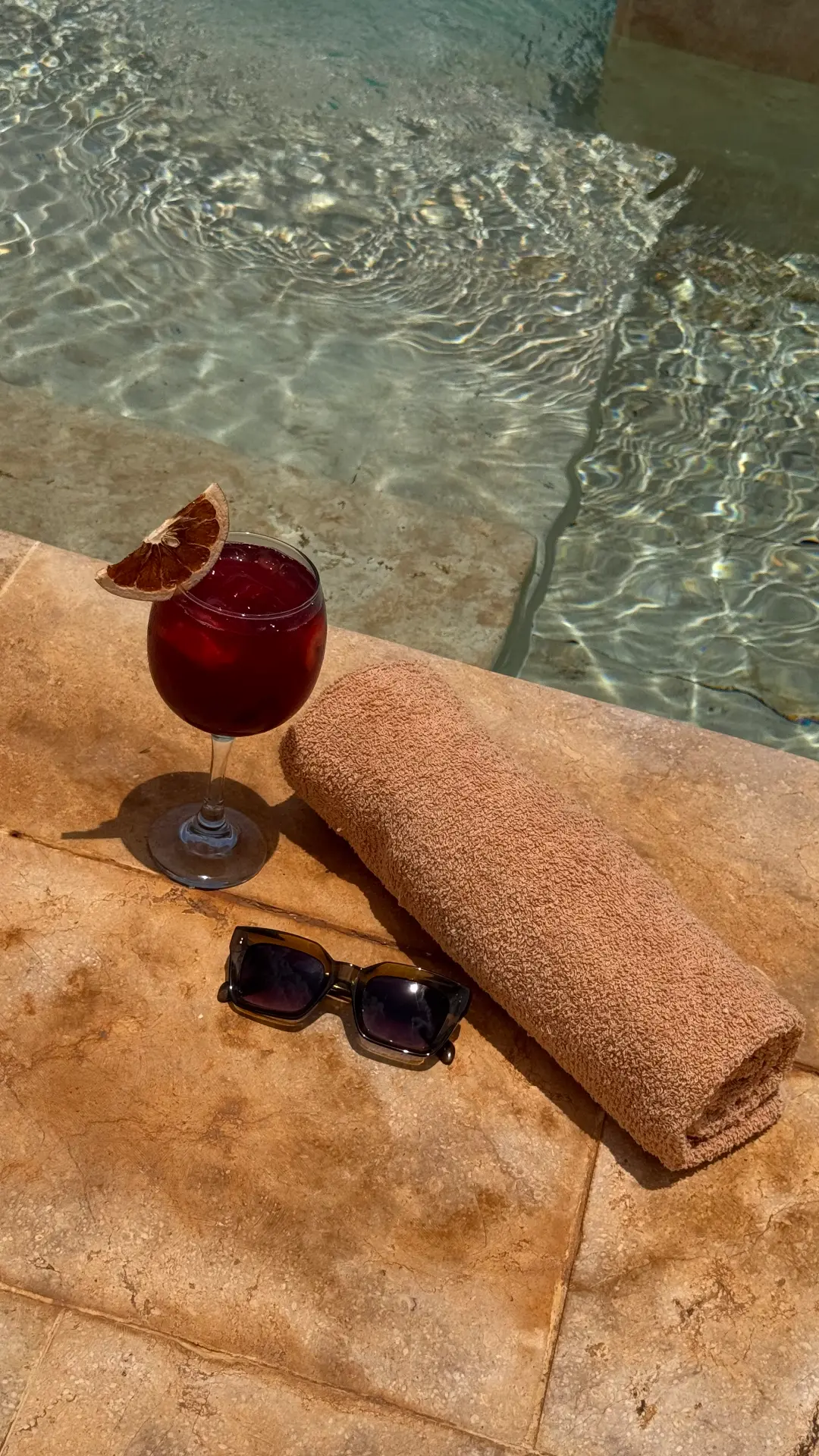 Cóctel al borde de la piscina con toalla y gafas